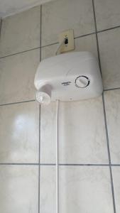 einem weißen Fön auf einem gefliesten Badezimmerboden in der Unterkunft Quarto privativo WC compartilhado in Joinville
