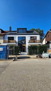 una gran casa blanca con muchas ventanas en Luxus Neubau 65m² City Wohnung: R, en Múnich