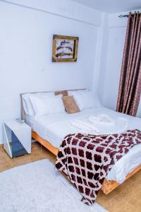 een slaapkamer met een bed met een deken erop bij Penthouse in Eldoret