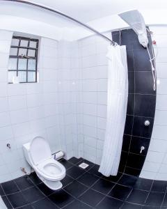 een badkamer met een toilet en een douchegordijn bij Penthouse in Eldoret