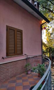 a house with a balcony with a window and plants at Villa Enrico in Monticchio