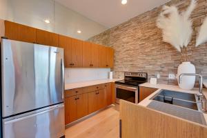 a kitchen with a stainless steel refrigerator and a brick wall at Bright San Diego Vacation Rental in Little Italy in San Diego