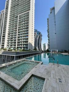 a swimming pool in a city with tall buildings at 5* Studio, 10min walk to Dubai Mall, 1min Bay Sqr in Dubai