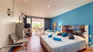 1 dormitorio con 1 cama grande y paredes azules en Appartement Varangue, Anse des rochers en Saint-François