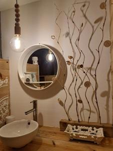 a bathroom with a round mirror and a sink at P'tites chambres dans la campagne de Marie Galante in Grand-Bourg