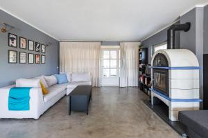 un soggiorno con divano bianco e camino di La Magnanella - Luxury B&B a Fornovo di Taro