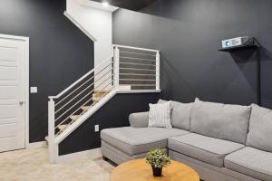 a living room with a couch and a staircase at Bright, Modern, Central - Theater Room, Sleeps 9 in Los Angeles