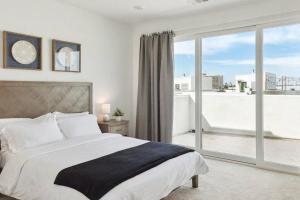 a bedroom with a large bed and a large window at Bright, Modern, Central - Theater Room, Sleeps 9 in Los Angeles