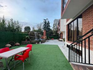 a patio with a table and chairs on a green lawn at villa with beautiful views in Tbilisi City