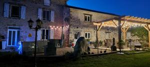 a building with a yard with a building with lights at La Petite Locherie in Oradour-Saint-Genest