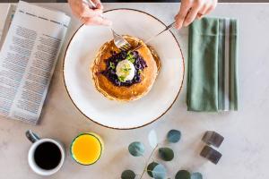 a person eating food on a plate with a fork and knife at Sheraton Carlsbad Resort & Spa in Carlsbad