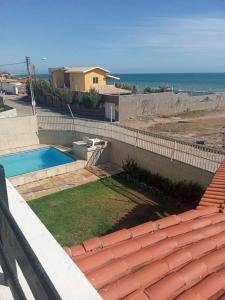 a backyard with a swimming pool and the ocean at Pousada e Hostel Lua de Tomate in Caucaia