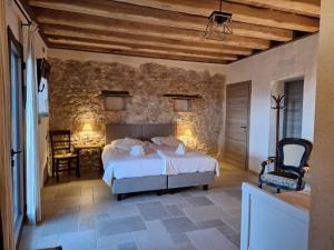 a bedroom with a bed and a stone wall at Agriturismo La Pina in Tarzo