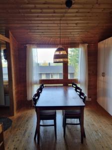 a dining room table with chairs and a pendant light at Lomariihi 11 in Muurame