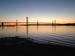 a bridge over a body of water at sunset at The Nook, Studio Apartment, South Queensferry in Queensferry