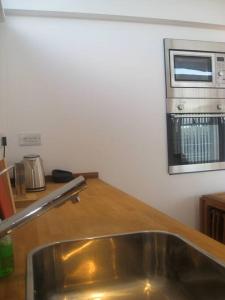 a kitchen with a sink and a microwave at The Nook, Studio Apartment, South Queensferry in Queensferry
