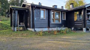 a black house with a porch and a window at Lomariihi 11 in Muurame
