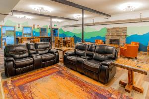 a living room with two leather chairs and a fireplace at Pintler's Portal Hostel in Anaconda