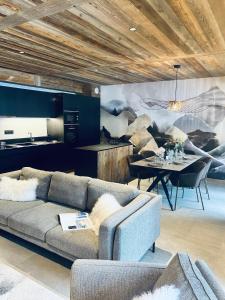 ein Wohnzimmer mit einem Sofa und einem Tisch in der Unterkunft Hameau des Prodains - Résidence in Morzine