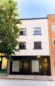 a white building with windows on a street at Newly Renovated 1 Bedroom Condo in Japantown! Near Gastown & Railtown! in Vancouver