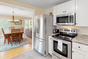 a kitchen with a stainless steel refrigerator and a dining room at Our Home on a Hill in Bethel