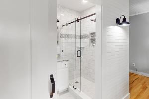 a white bathroom with a shower with a glass door at Our Home on a Hill in Bethel