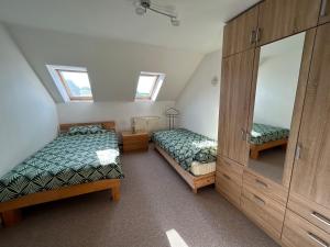 a attic bedroom with two beds and a dresser at Monteurwohnung nahe der Talsperre Pöhl im Vogtland in Pöhl