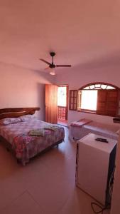 a bedroom with two beds and a ceiling fan at Pousada Blues in Ipiabas