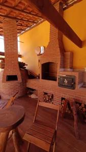 a living room with a brick fireplace and a table at Pousada Blues in Ipiabas