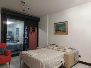 ein Schlafzimmer mit einem Bett und einem roten Stuhl in der Unterkunft APPARTAMENTO SUL MARE KATE in Genua