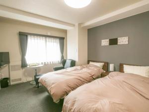 a bedroom with two beds and a desk and a window at KAMUY RERA - Vacation STAY 62288v in Kushiro