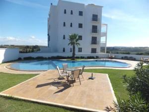 a patio with a table and chairs next to a building at Apartamento en Residencia Jardines de Asilah in Asilah