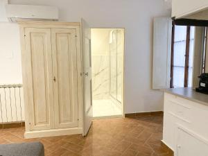 a kitchen with a cupboard and a door to a bathroom at Palazzo D'Oltrarno - Residenza D'Epoca in Florence