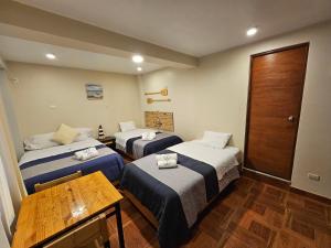 una camera d'albergo con due letti e un tavolo di EL FARO HOTEL a Chala