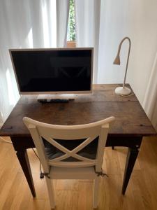 una scrivania in legno con monitor e sedia di Appartamento Simona a Castiglione dei Pepoli