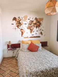 um quarto com uma cama com um mapa do mundo na parede em Monte das Flores 