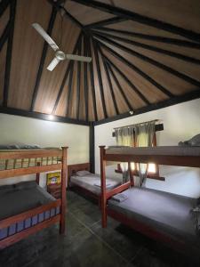 a room with three bunk beds and a ceiling at finca playa alta in Palmira