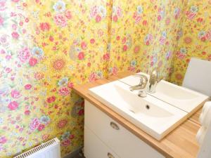 a bathroom with a sink and a flowery wallpaper at Atmospheric Lapland Villa - Magical River View in Rovaniemi +25 photos