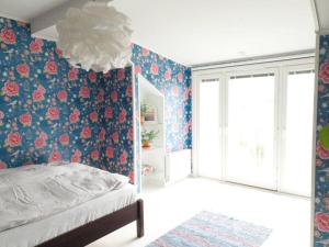 a bedroom with a bed with a floral wallpaper at Atmospheric Lapland Villa - Magical River View in Rovaniemi