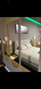 1 dormitorio con 1 cama con espejos en la pared en Jentelmen rooms, en Haifa