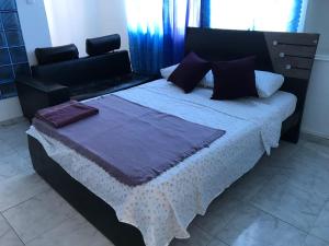 a bedroom with a large bed with purple pillows at Los delfines in Cartagena de Indias