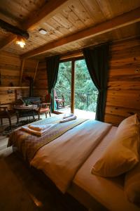 a large bed in a room with a large window at bungalove tatil köyü in Çamlıhemşin