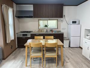 Enoshima HOME2 - Vacation STAY 20227v في فوجيساوا: مطبخ مع طاولة وكراسي في مطبخ
