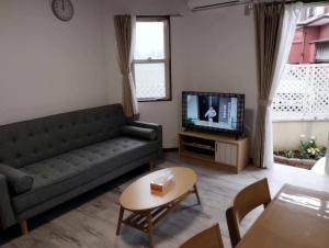 Enoshima HOME2 - Vacation STAY 20227v في فوجيساوا: غرفة معيشة مع أريكة وتلفزيون
