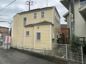 藤沢市にあるEnoshima HOME2 - Vacation STAY 20227vの大黄色の家が柵の後ろにある