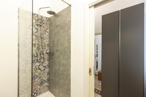 Un baño con ducha con puerta de cristal. en Kepos Rooms and Suites, en Palermo