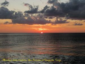 una puesta de sol sobre el océano con el sol en la distancia en Casa Rosanna, en Campeche