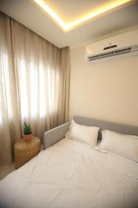 a bedroom with a large white bed with a window at Flat Beira Mar in Fortaleza