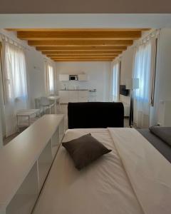 una camera bianca con un grande letto e un soggiorno di Residence Duomo a Castelfranco Veneto
