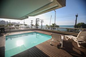 a swimming pool on a deck with two chairs at Flat Beira Mar in Fortaleza